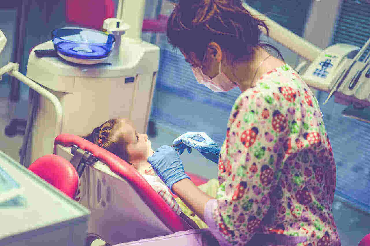 little girl undergoing dental checkup with her dentist