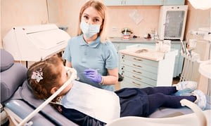 A young girl with inhalation sedation during her dental treatment.